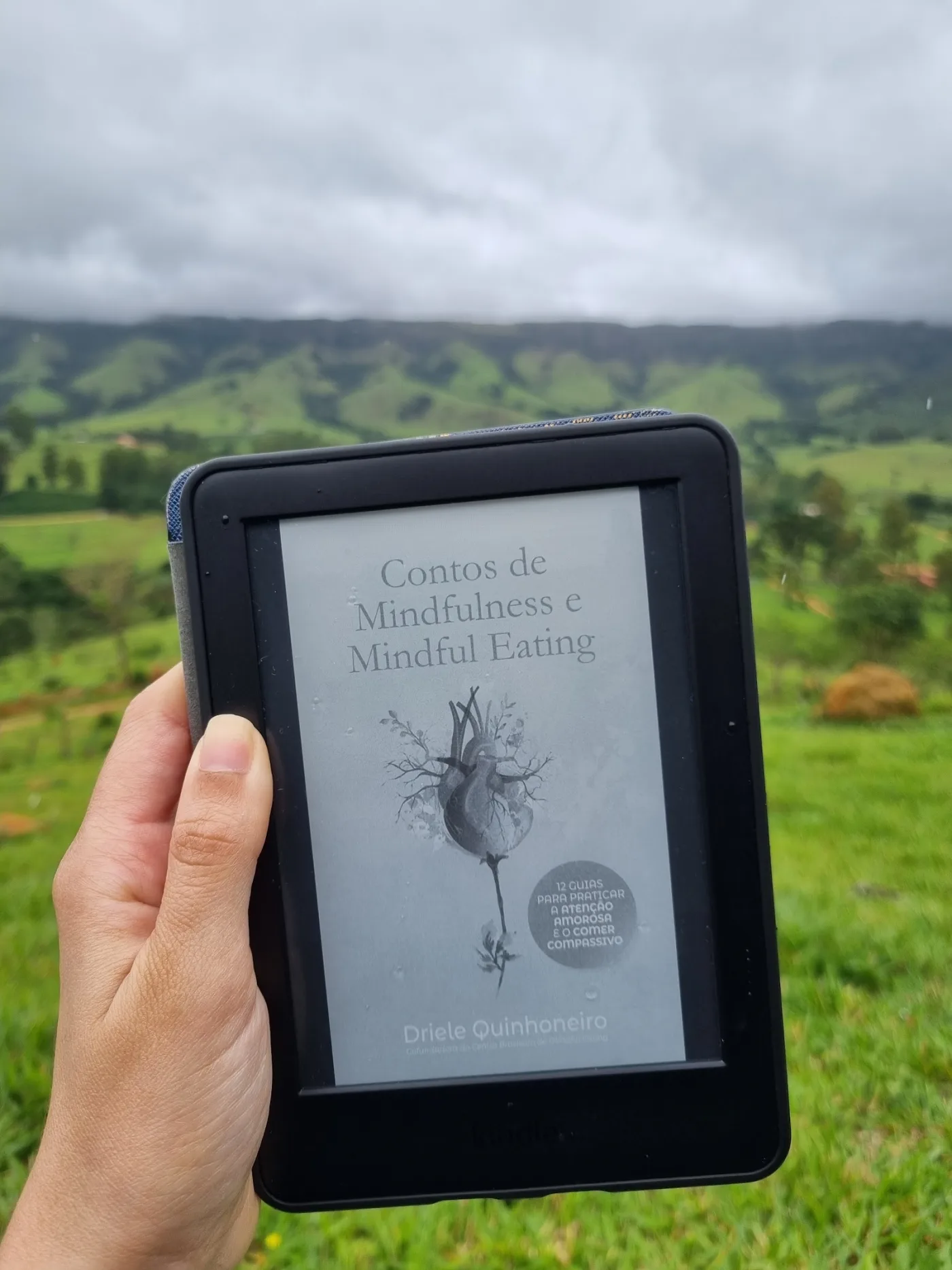 Contos de Mindfulness e Mindful Eating no Kindle, diante de paisagem montanhosa